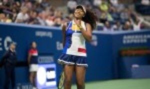 Naomi Osaka grabbed the headlines on a rain-interrupted day two of the US Open as she blasted her way past the defending champion Angelique Kerber 6-3 6-1 in just 64 minutes