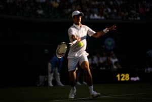 Novak Djokovic Wimbledon 2019 in the dusk plays a flying forehand