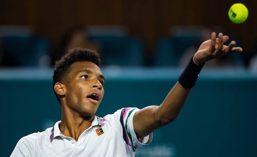 Felix Auger-Aliassime serves