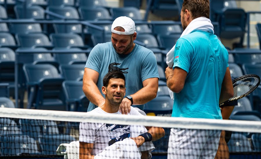 Novak Djokovic receives should treatment whilst chatting to Wawrinka in practise.jpg