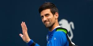 Novak Djokovic smiles and waves